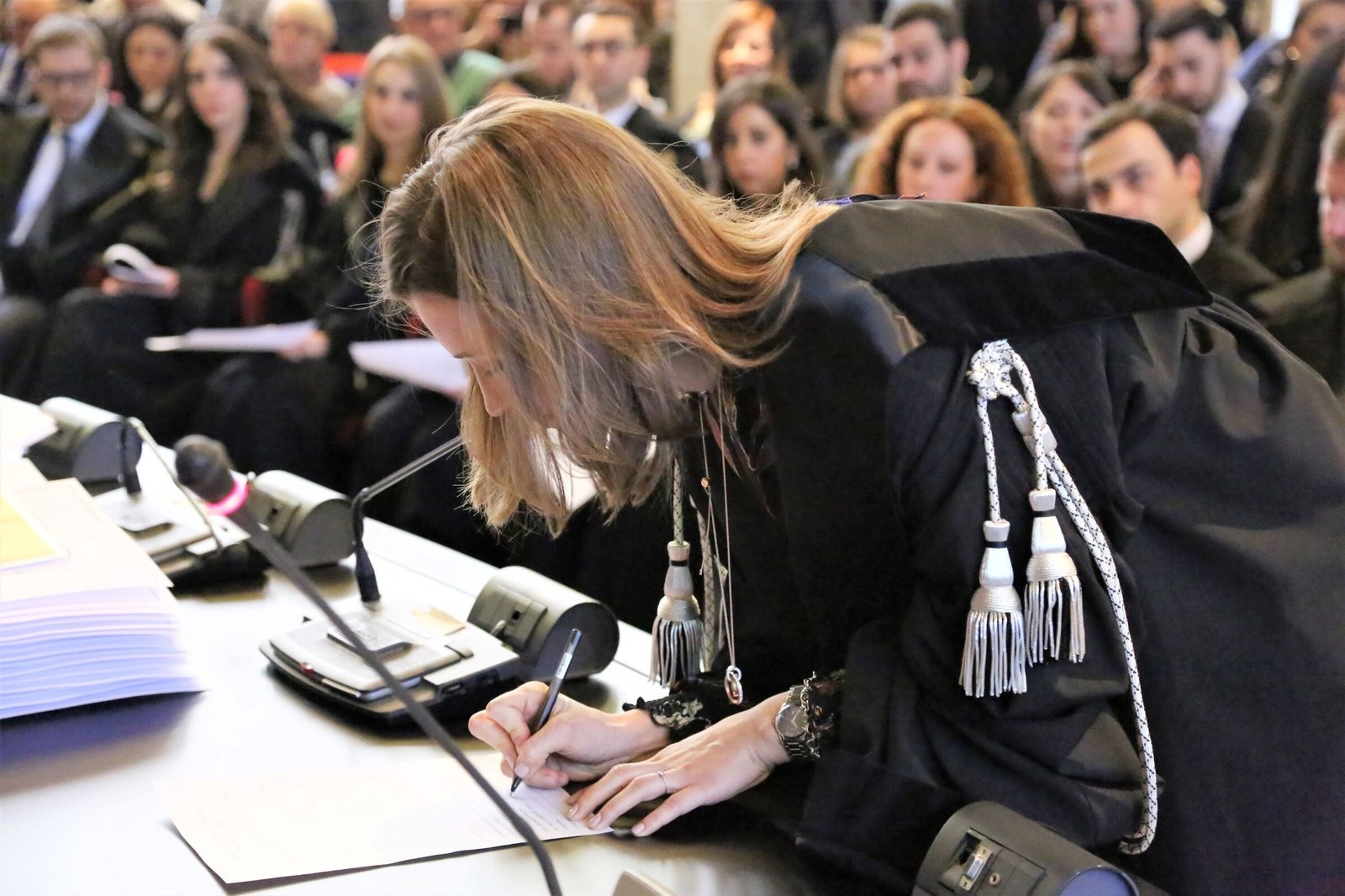 Avv. Giulia Dalle Carbonare in toga firma il registro durante la cerimonia di giuramento per l’iscrizione all’albo